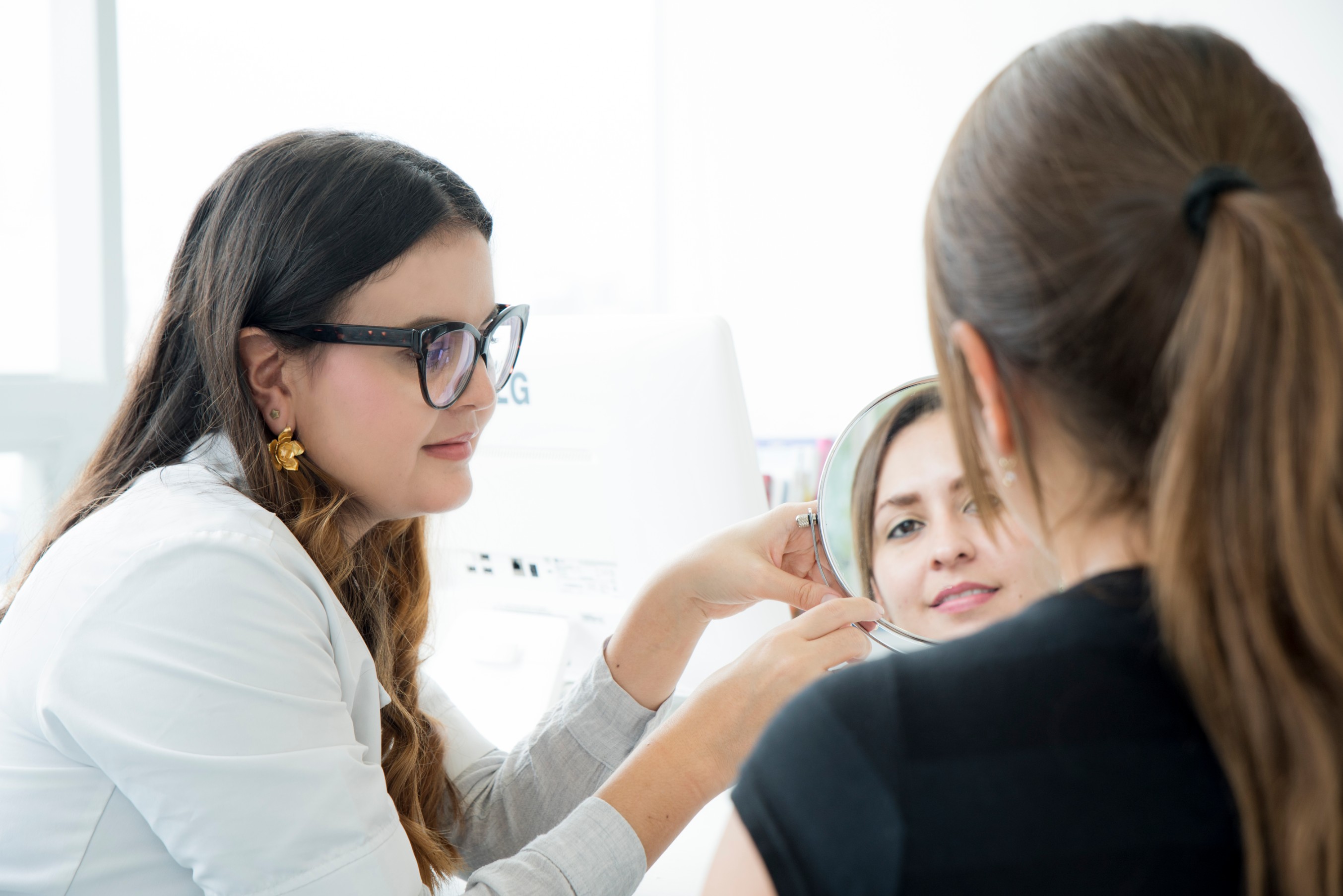 La Dra. Luisa Ríos durante una consulta dermatológica con una niña y su acompañante